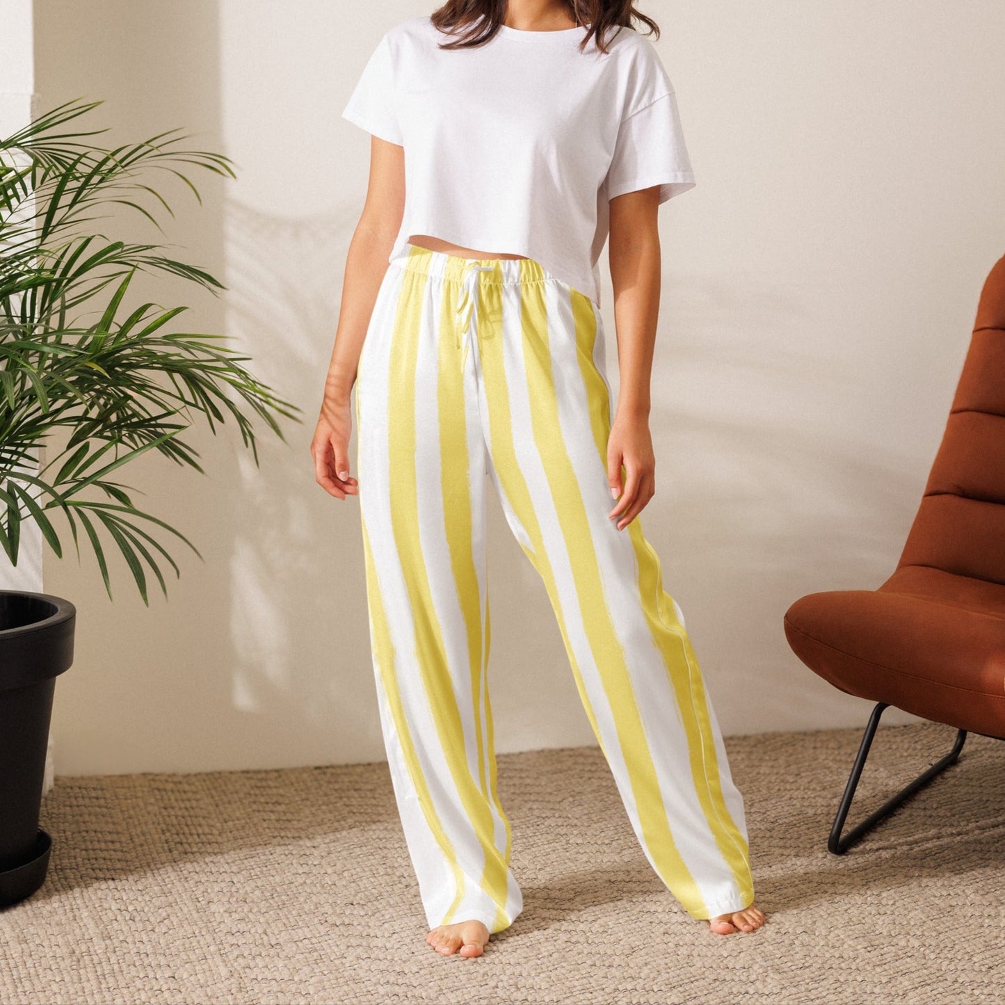 Model in butter yellow striped pajama pants paired with white tee, perfect for effortless everyday loungewear or travel outfits.