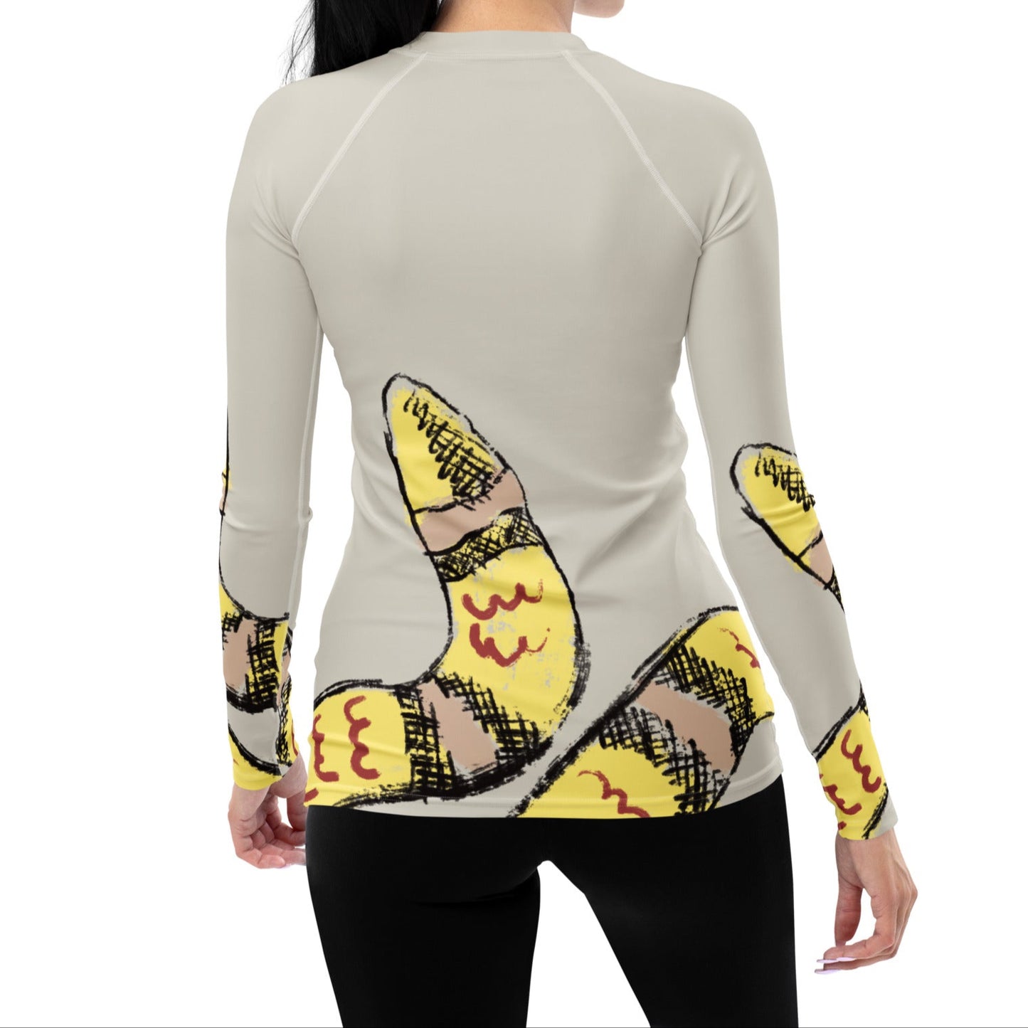 Woman wearing yellow snake print long-sleeve rash guard by Panther & Palm, showcasing UPF 50+ activewear with ergonomic fit.