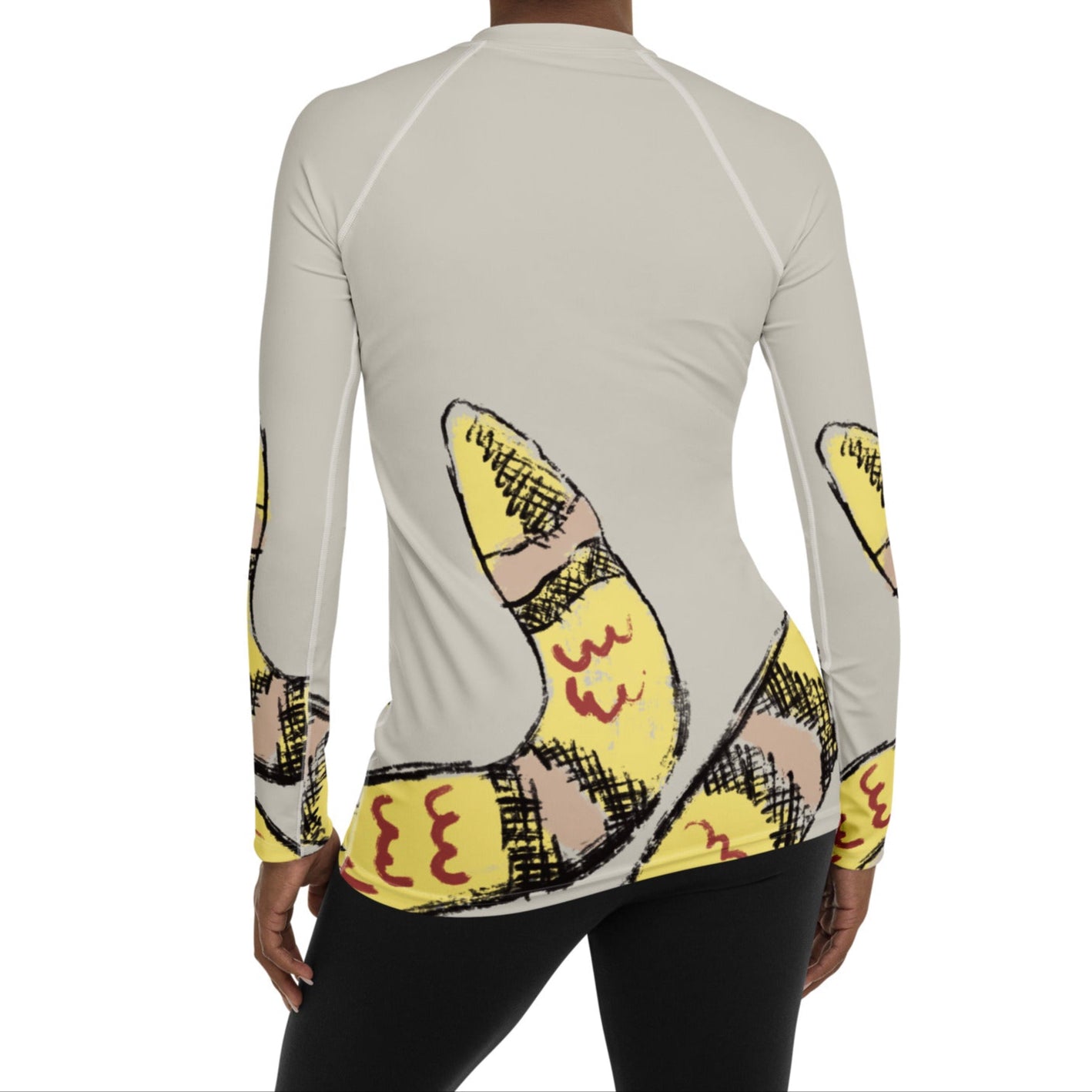 Woman wearing yellow snake print long-sleeve rash guard by Panther & Palm, showcasing UPF 50+ activewear with ergonomic fit.