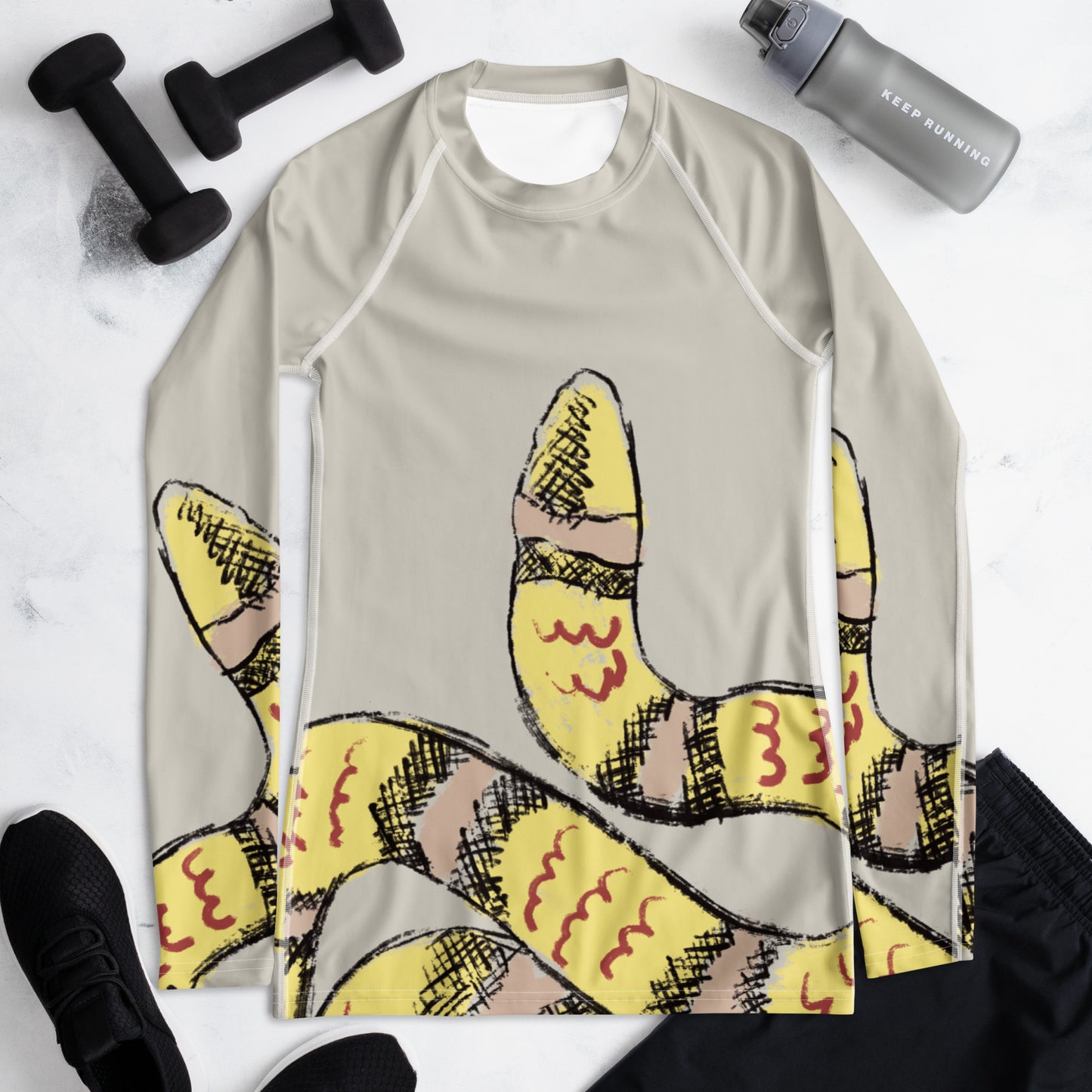 Rash guard top with snake design shown with workout accessories, made for running, training, and ocean sports.