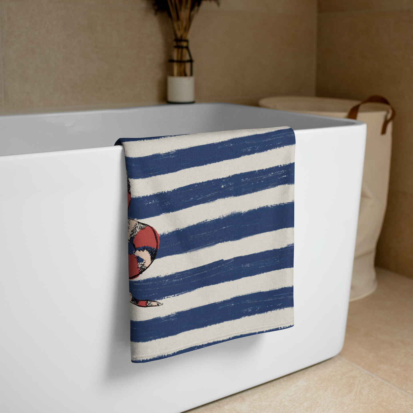 Designer snake towel by Panther & Palm folded over tub in modern bathroom – bold red kingsnake on navy stripe towel for stylish home or beach use