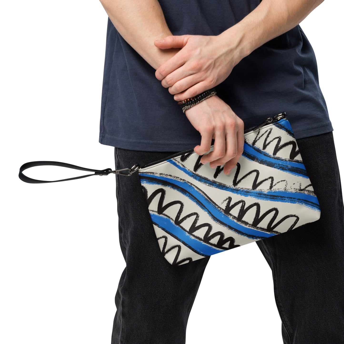 Man holds Panther & Palm crossbody bag with abstract tropical print, styled with casual navy tee and jeans.