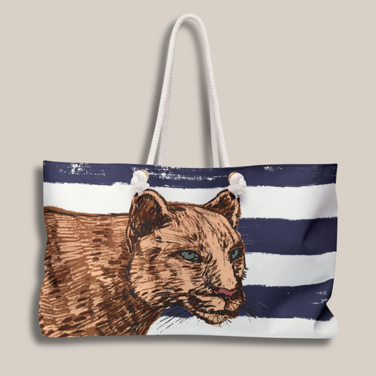 Detailed front view of lion illustration against navy and white Breton stripes on the spacious weekender bag by Panther & Palm