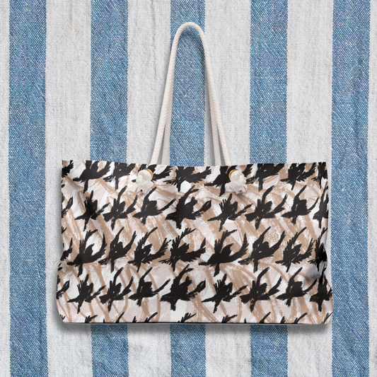 Houndstooth Sketch Weekender Bag displayed against a bold blue-and-white striped backdrop, emphasizing its artistic design and travel-ready size.